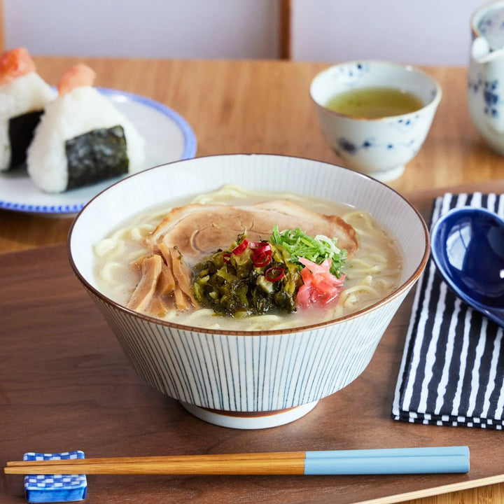 Elegant ramen bowl with fine vertical blue lines and a warm white glaze, perfect for serving hearty noodle soups.