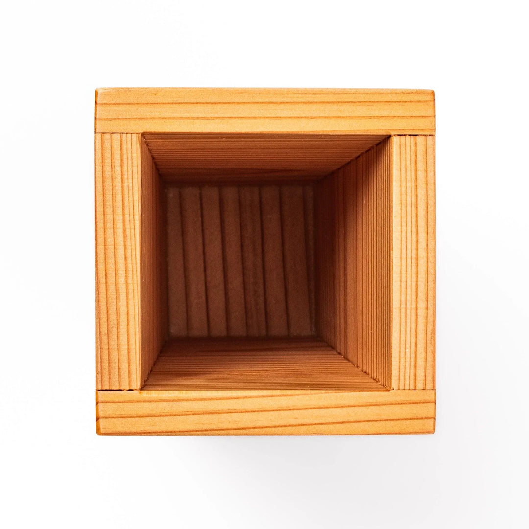 Cedar sake cup with smooth rim and visible grain, offering a warm, aromatic touch to traditional drinkware.