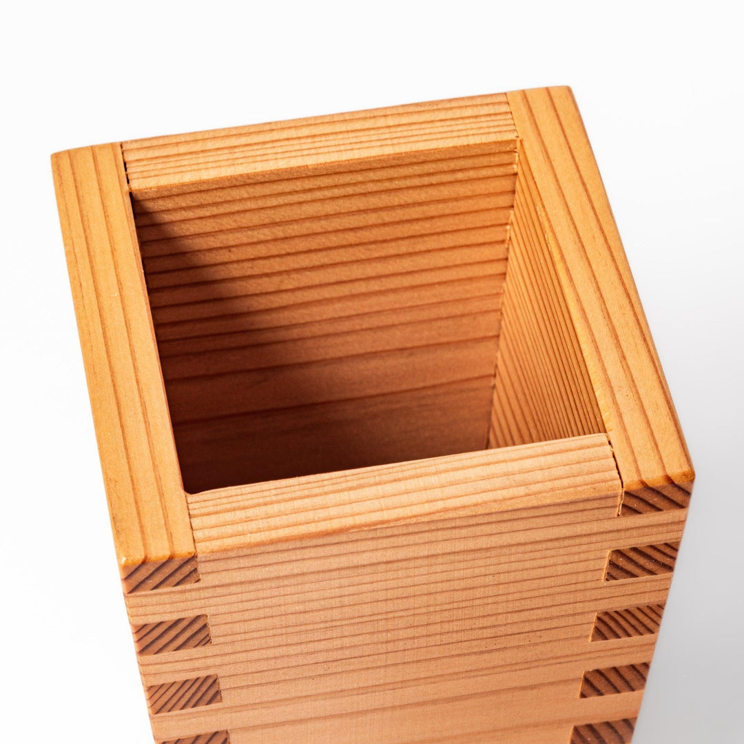 Cedar sake cup with smooth rim and visible grain, offering a warm, aromatic touch to traditional drinkware.