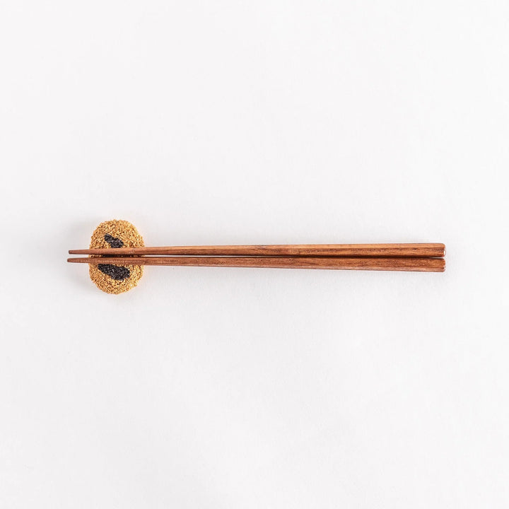 Japanese croquette shaped ceramic chopstick rest with golden brown finish adding fun dining accent.