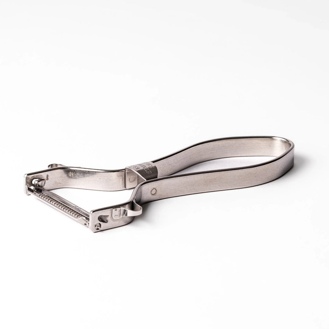 Japanese daikon julienne peeler with stainless steel blade and ergonomic looped handle for thin vegetable strips