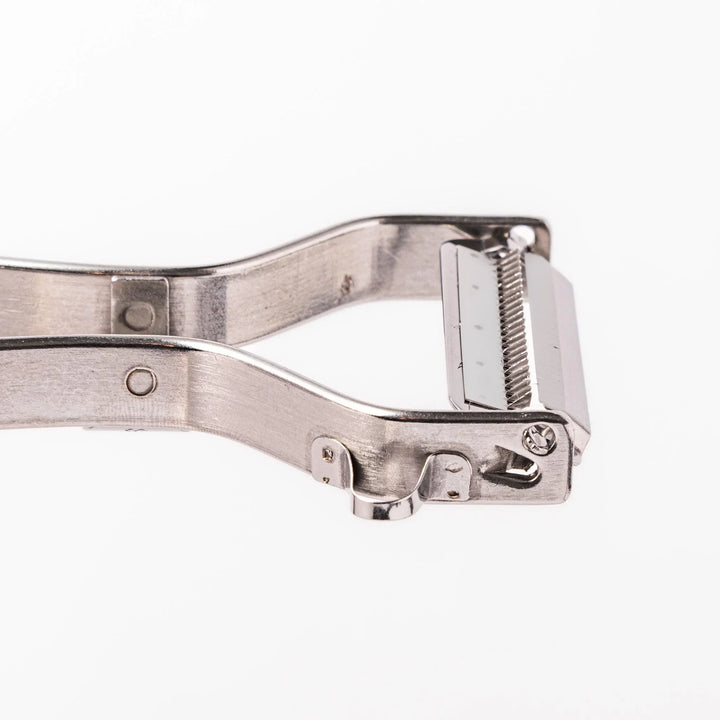 Japanese daikon julienne peeler with stainless steel blade and ergonomic looped handle for thin vegetable strips