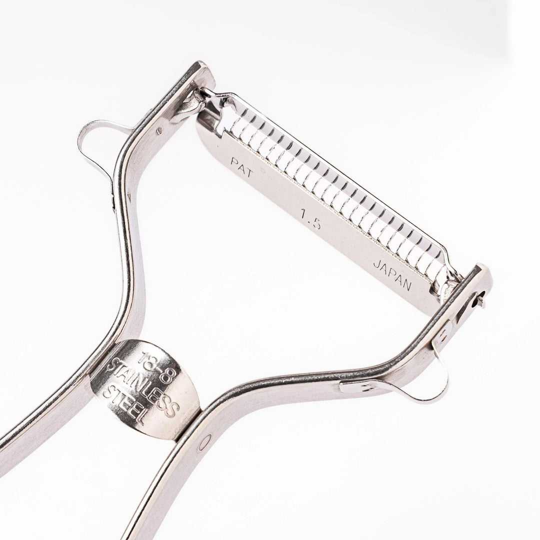 Japanese daikon julienne peeler with stainless steel blade and ergonomic looped handle for thin vegetable strips