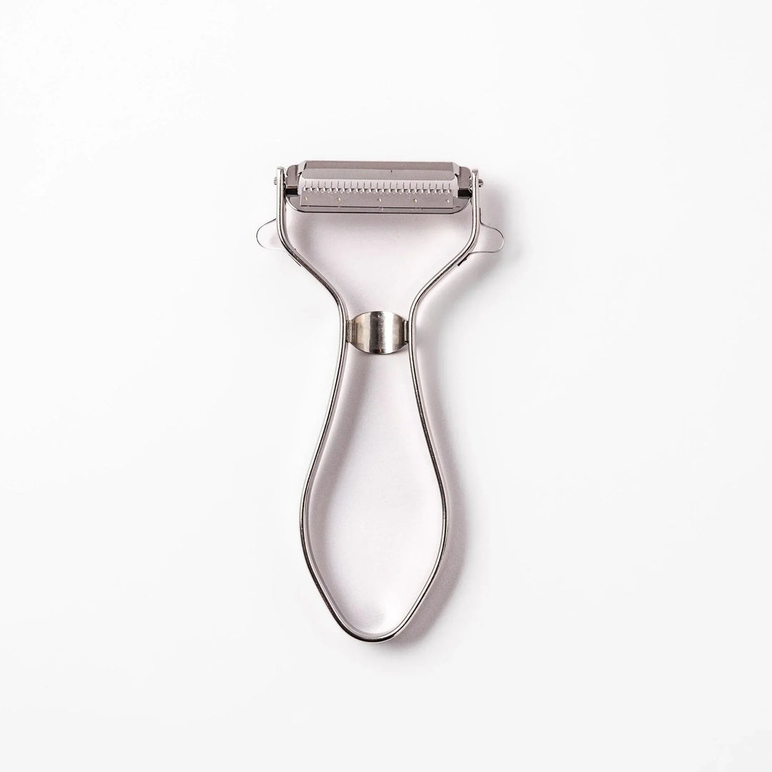 Japanese daikon julienne peeler with stainless steel blade and ergonomic looped handle for thin vegetable strips