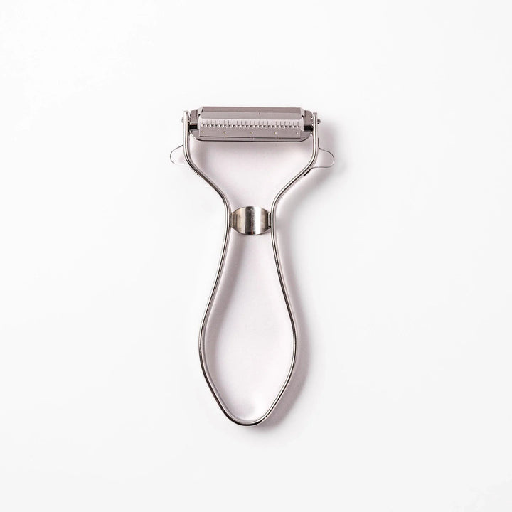 Japanese daikon julienne peeler with stainless steel blade and ergonomic looped handle for thin vegetable strips