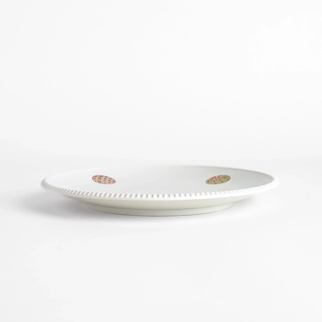 White dinner plate with vibrant temari ball designs, showcasing intricate details.