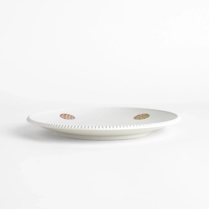 White dinner plate with vibrant temari ball designs, showcasing intricate details.