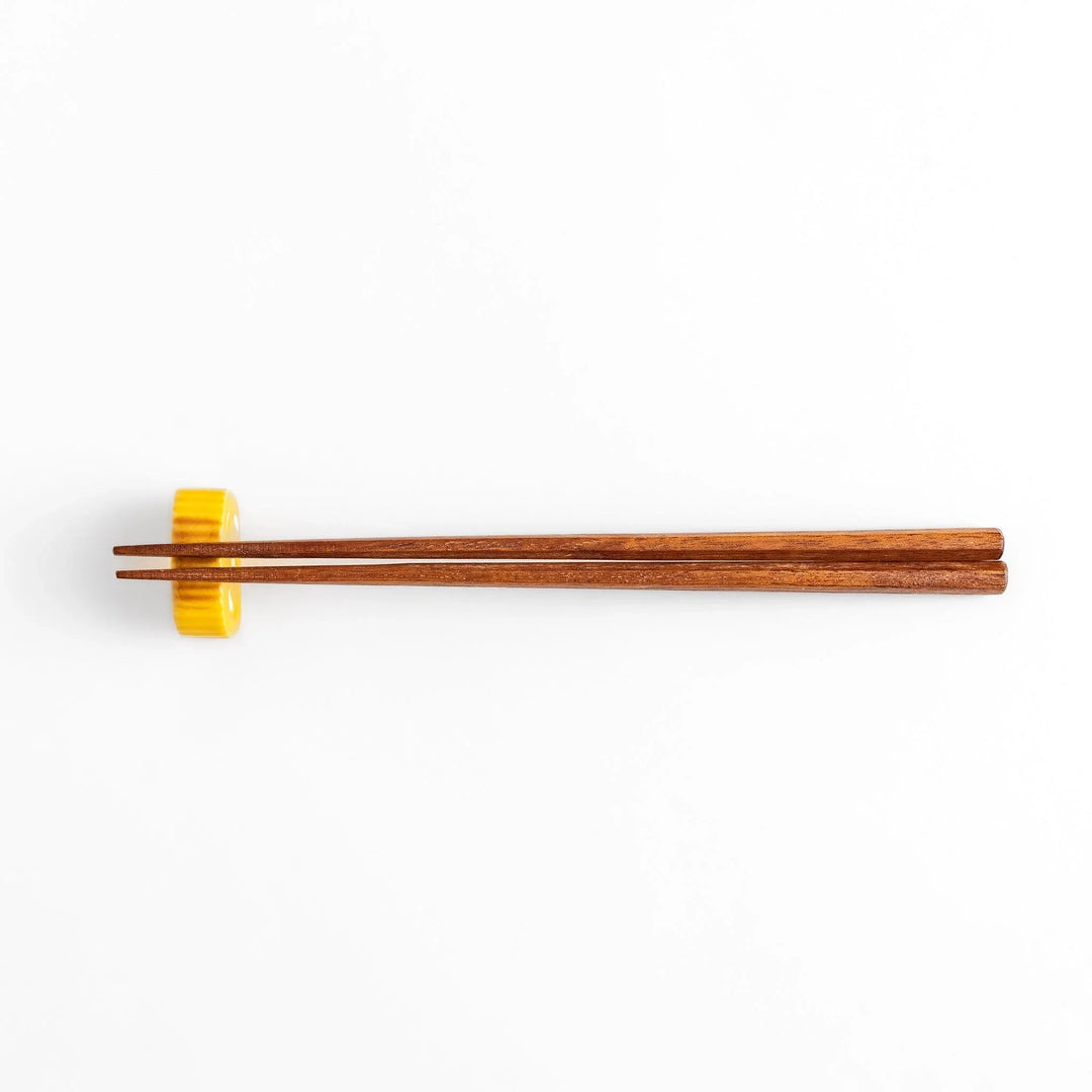 Japanese rolled omelette chopstick rest with bright yellow color adding fun and authentic dining accent.
