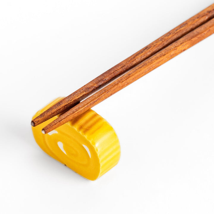 Japanese rolled omelette chopstick rest with bright yellow color adding fun and authentic dining accent.