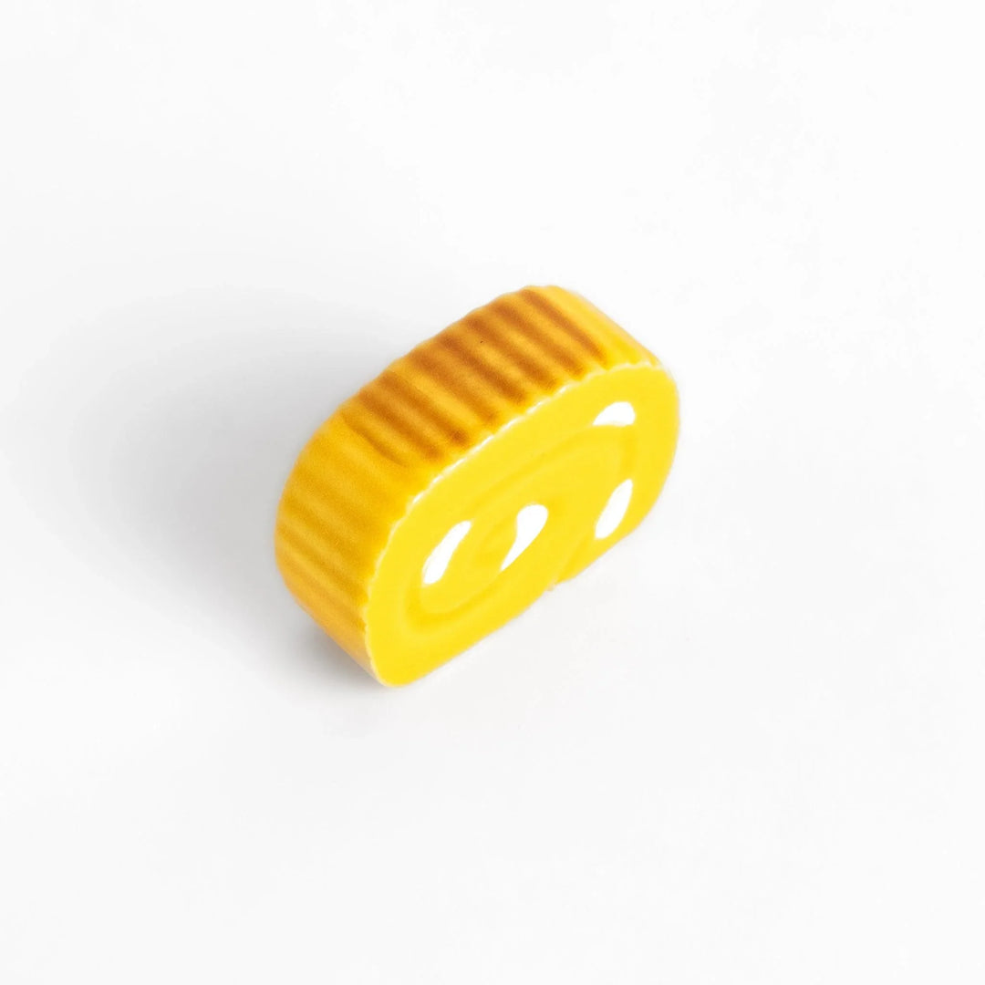 Japanese rolled omelette chopstick rest with bright yellow color adding fun and authentic dining accent.