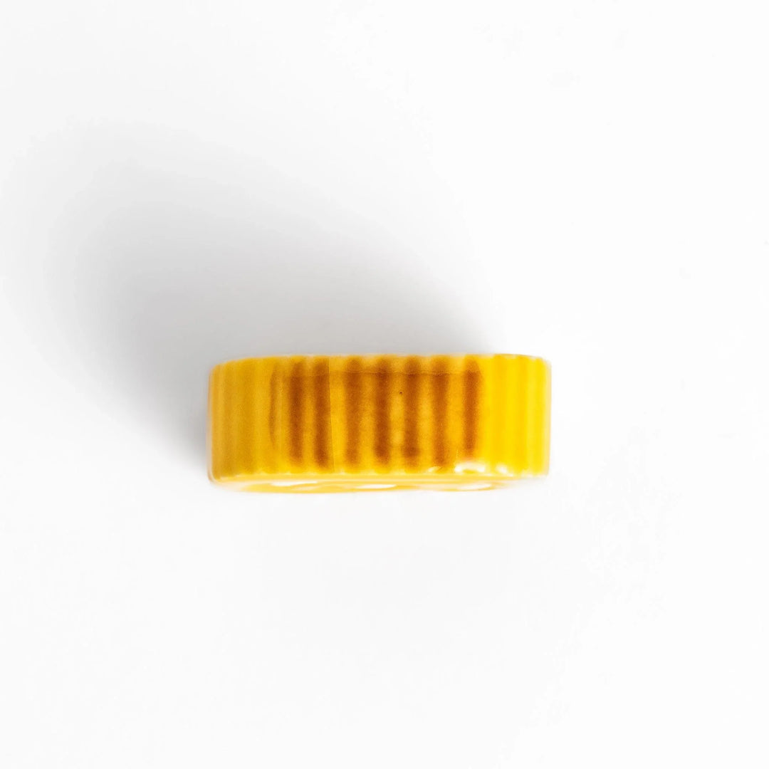 Japanese rolled omelette chopstick rest with bright yellow color adding fun and authentic dining accent.