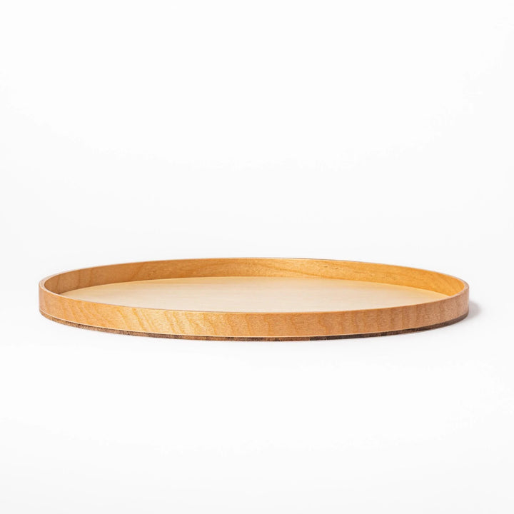 Minimalist Japanese round wooden tray with raised edge for serving tea snacks or organizing small items.