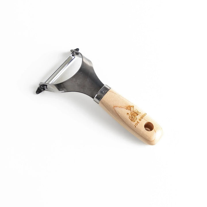 Japanese wood handle peeler with sharp stainless steel blade designed for smooth effortless vegetable peeling.