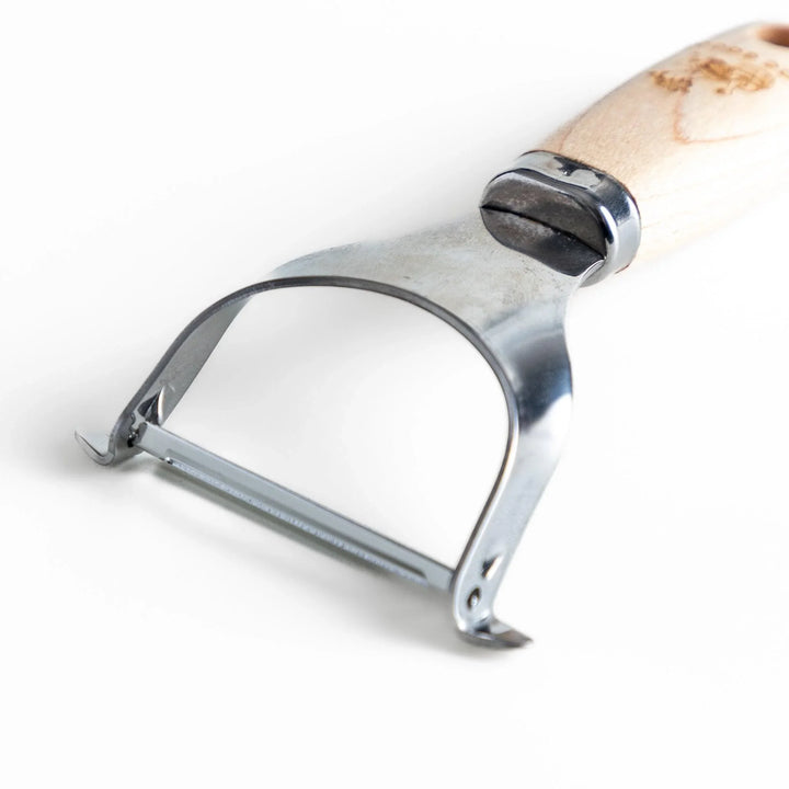 Japanese wood handle peeler with sharp stainless steel blade designed for smooth effortless vegetable peeling.