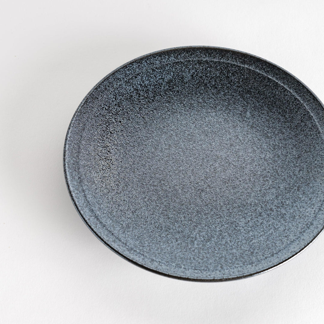 A round black salad plate with a subtle, rustic texture, ideal for modern table settings.