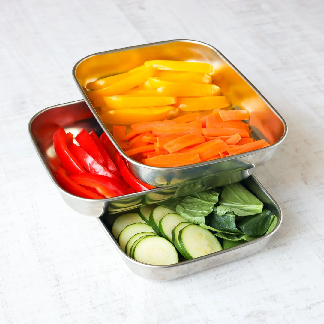 Colorful sliced vegetables arranged in stackable stainless steel prep trays for organized Japanese cooking.