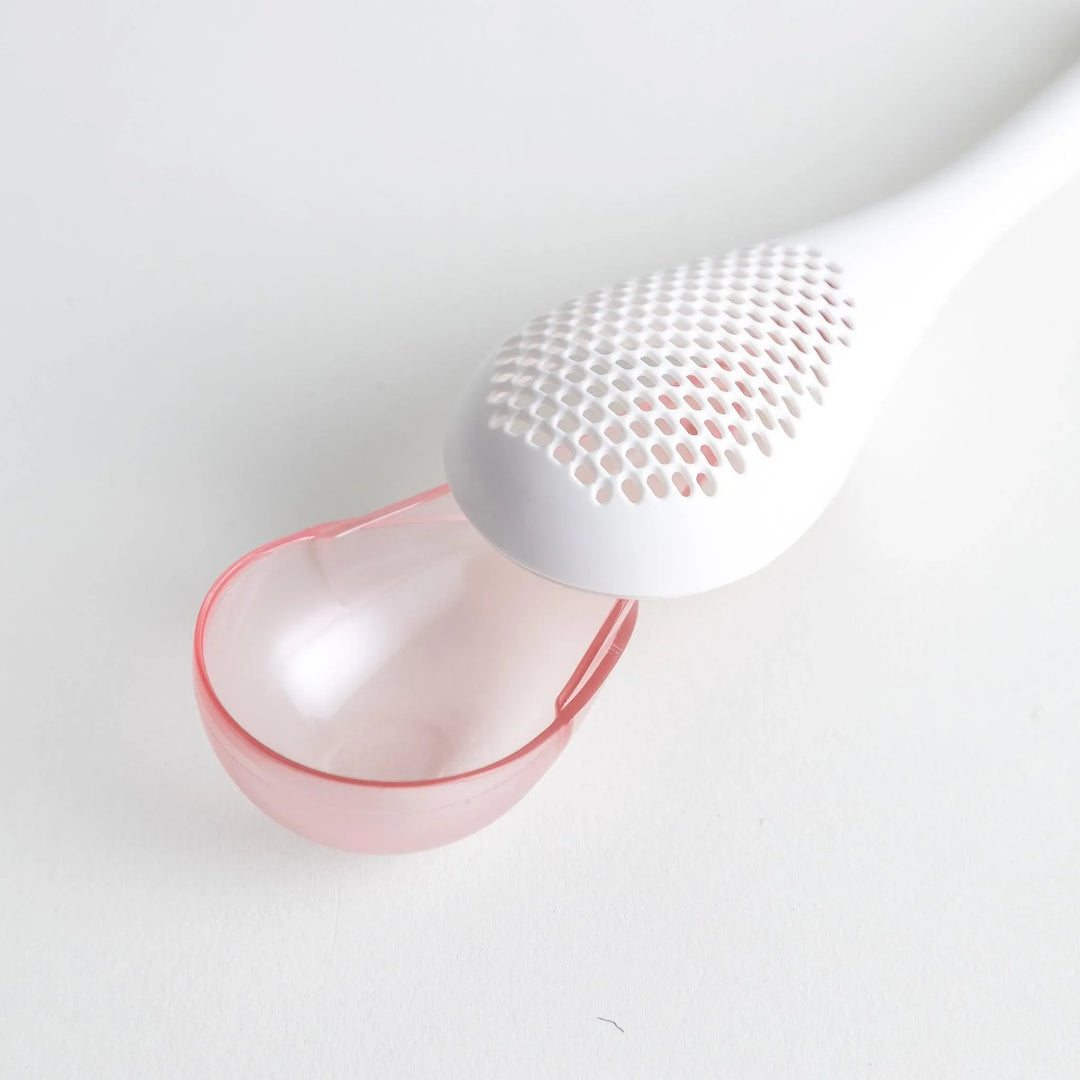 – A modern, white maraca-shaped spice sifter with a textured surface and a pink handle.