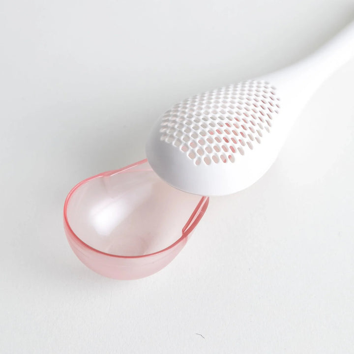 – A modern, white maraca-shaped spice sifter with a textured surface and a pink handle.