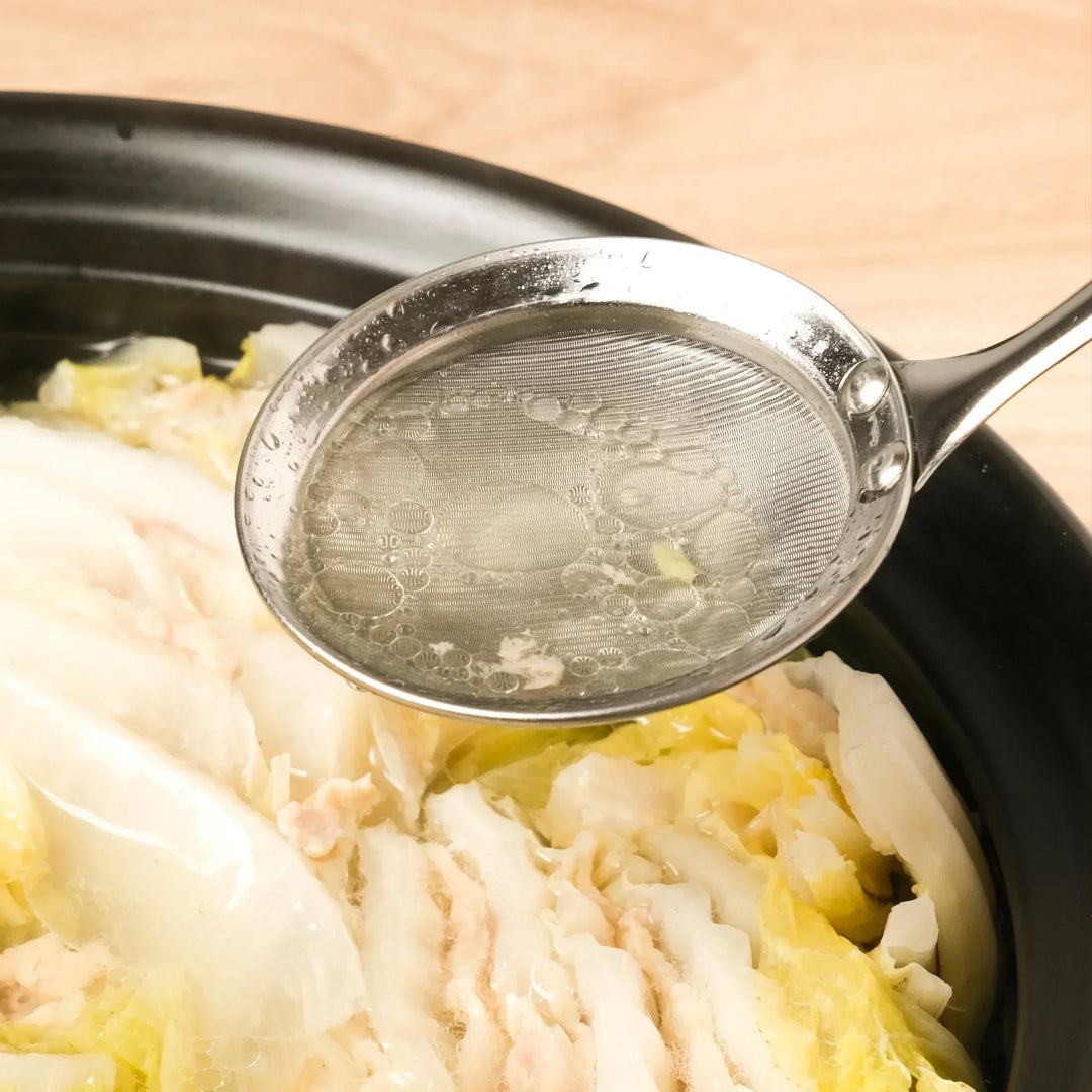 Stainless steel skimmer with fine mesh and long handle perfect for removing scum from soups or broths.