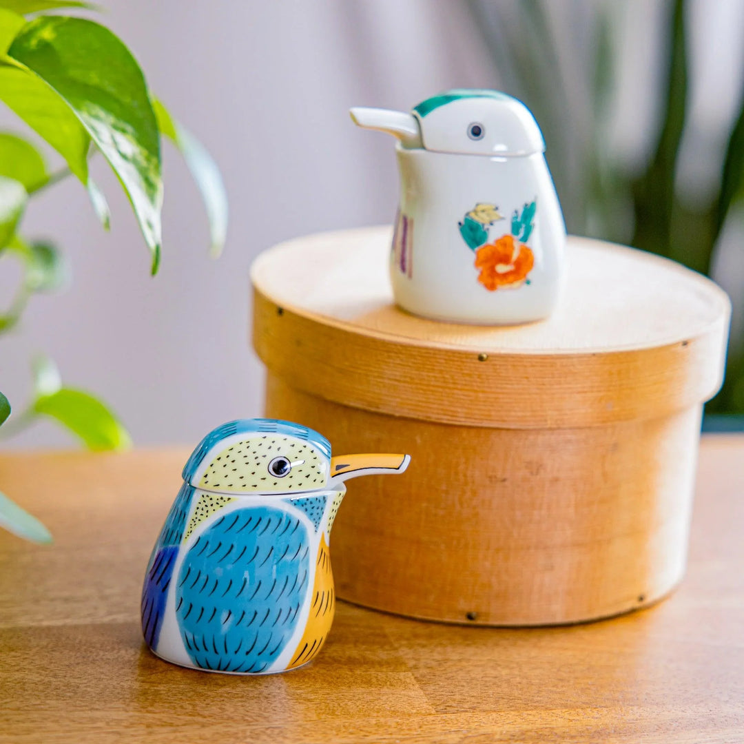 Japanese porcelain kingfisher soy sauce dispenser with hand painted design, displayed on wooden table in natural light