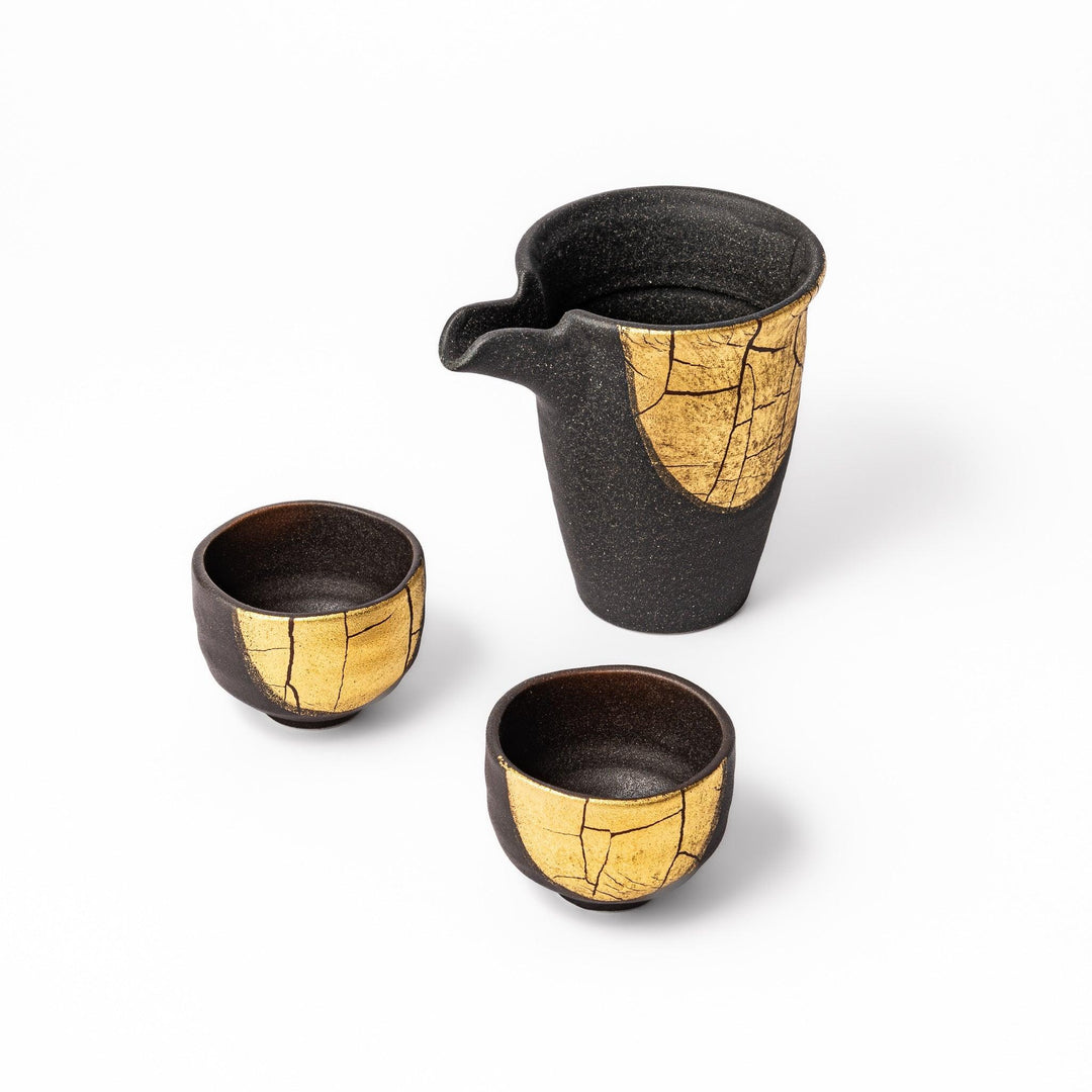 Black and gold Kutani sake set with spouted carafe and cups, blending Kintsugi art with modern elegance.