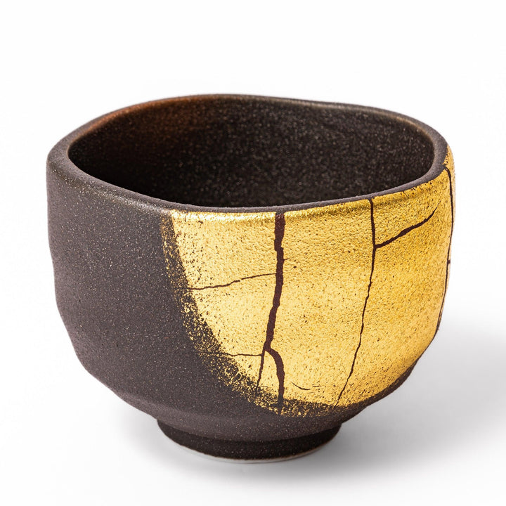 Black and gold Kutani sake set with spouted carafe and cups, blending Kintsugi art with modern elegance.
