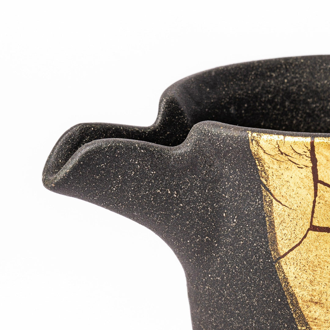 Black and gold Kutani sake set with spouted carafe and cups, blending Kintsugi art with modern elegance.