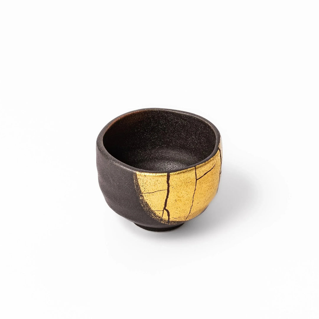 Black and gold Kutani sake set with spouted carafe and cups, blending Kintsugi art with modern elegance.