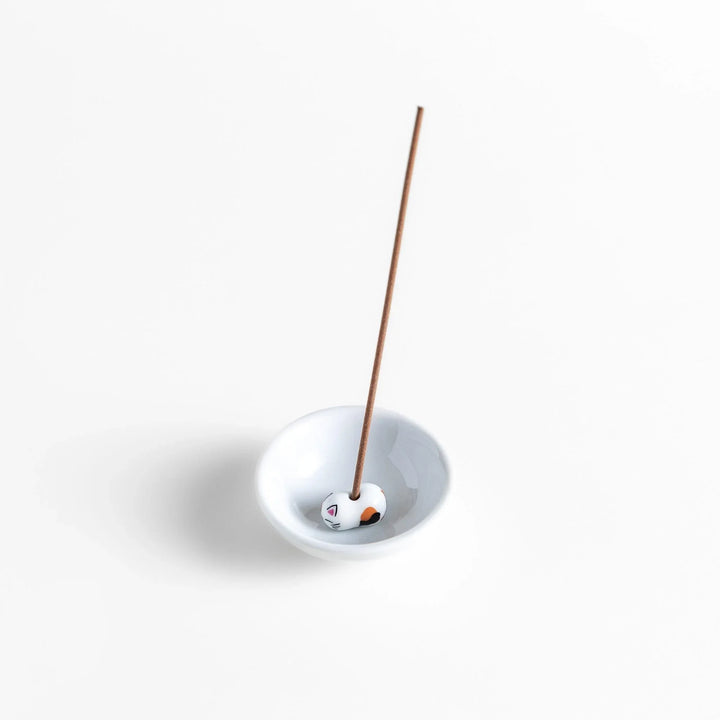 White ceramic incense holder with a small calico cat figurine inside the bowl, adding a touch of warmth to your daily rituals