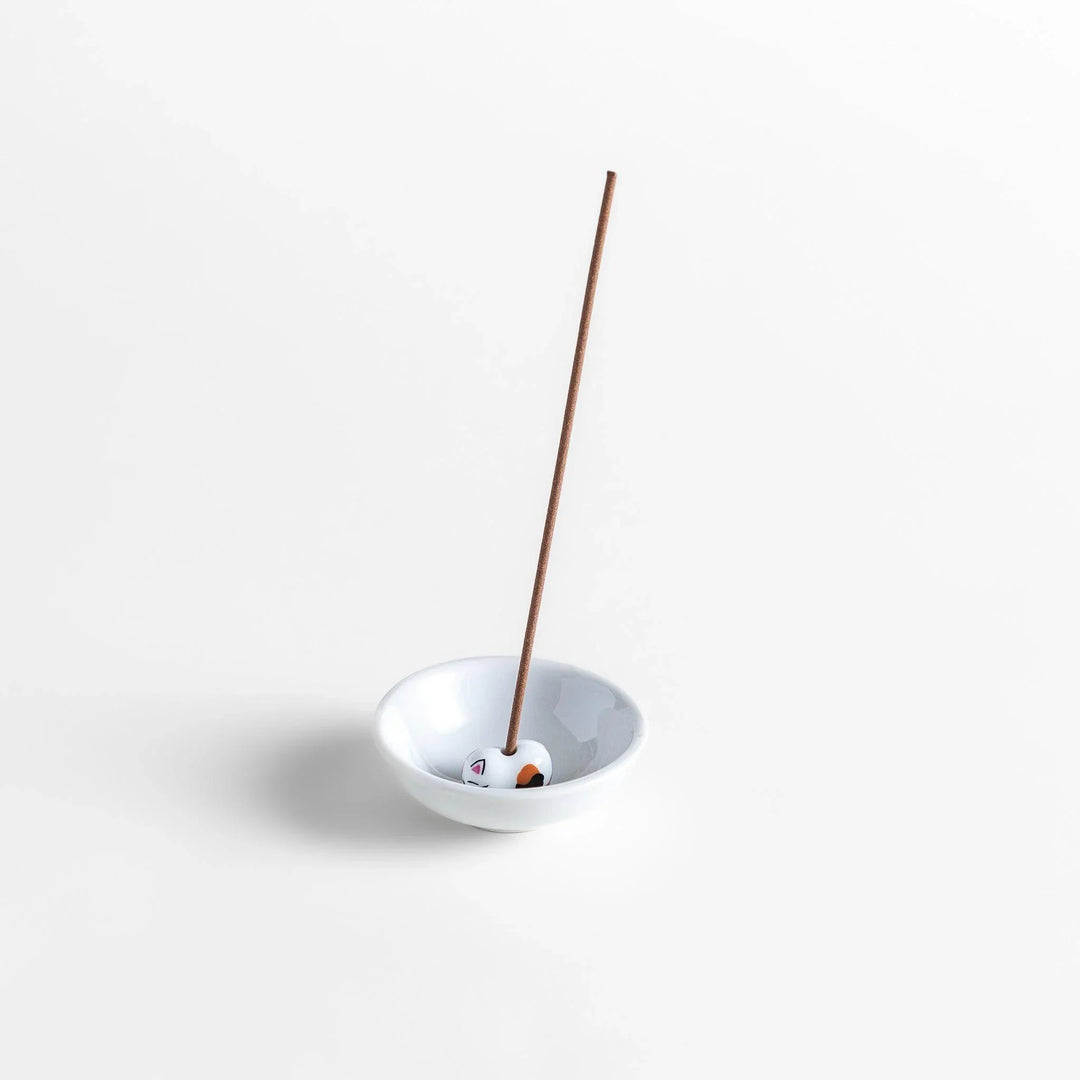 White ceramic incense holder with a small calico cat figurine inside the bowl, adding a touch of warmth to your daily rituals