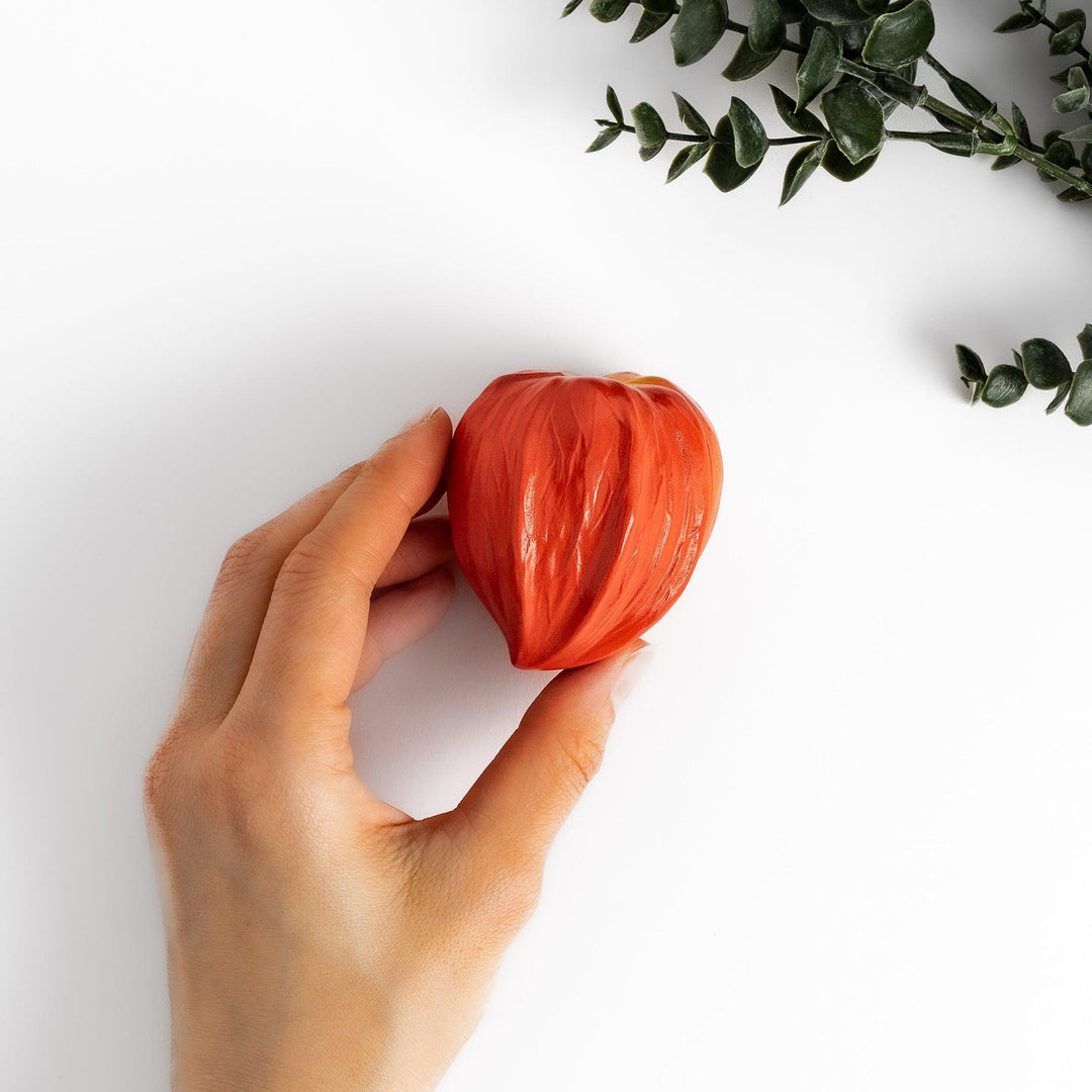 Handcrafted ceramic lidded bowl shaped like an orange lantern plant, ideal for serving condiments or small treats.