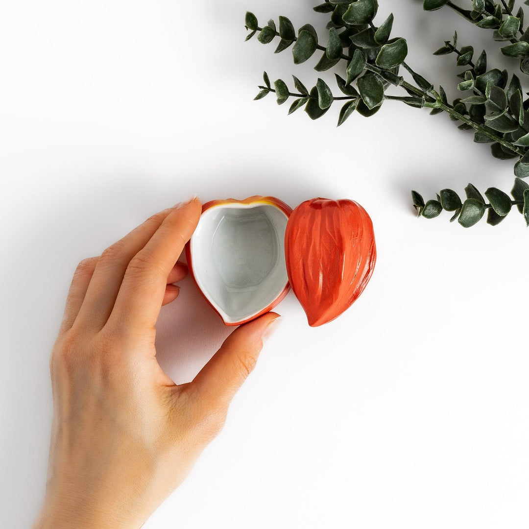 Handcrafted ceramic lidded bowl shaped like an orange lantern plant, ideal for serving condiments or small treats.