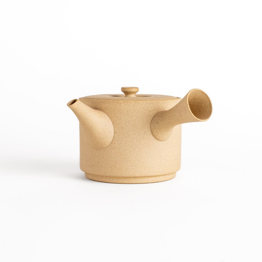 Modern beige teapot with round body horizontal spout and lid textured ceramic for minimalist tea.