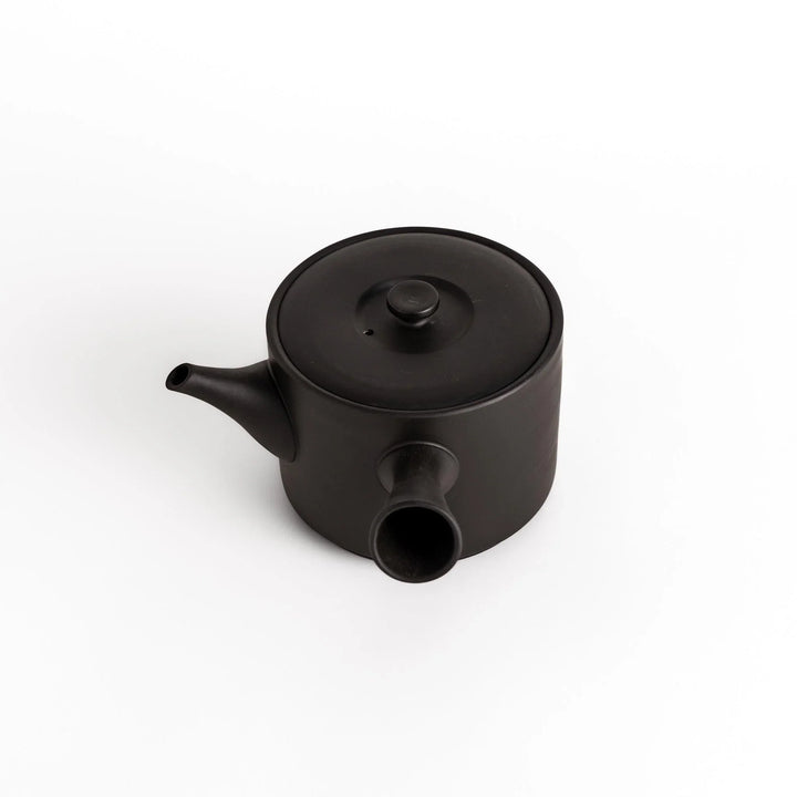 Slightly angled view of the black teapot, highlighting its balanced shape and horizontal spout and handle.