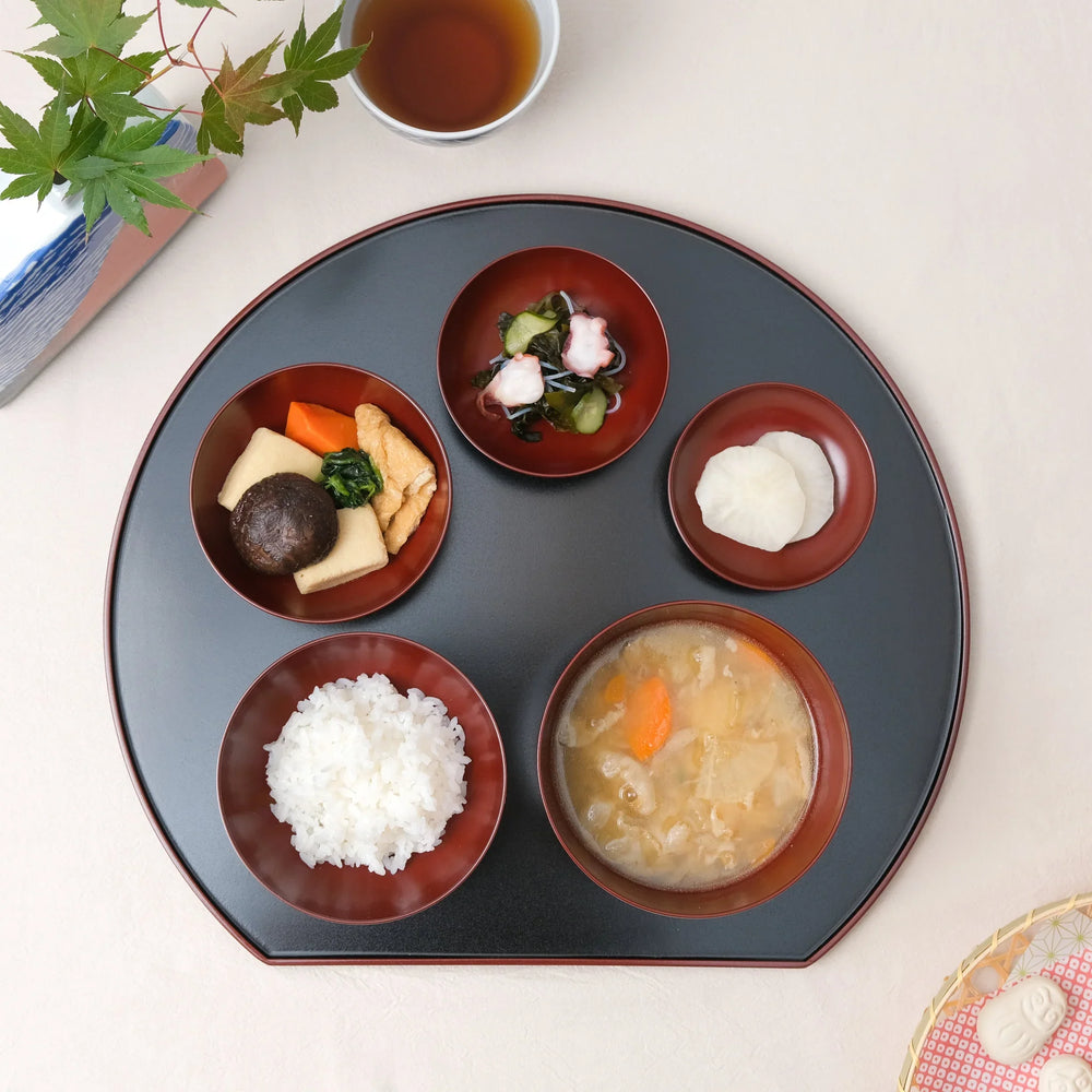 Japanese Oryoki bowl set with rice miso soup vegetables pickles and octopus salad on lacquer tray with tea.