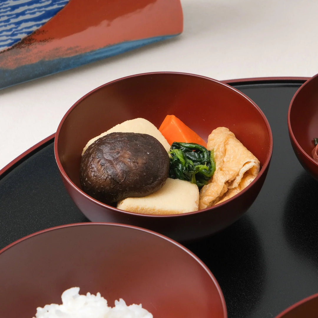 Japanese Oryoki bowl set with rice miso soup vegetables pickles and octopus salad on lacquer tray with tea.