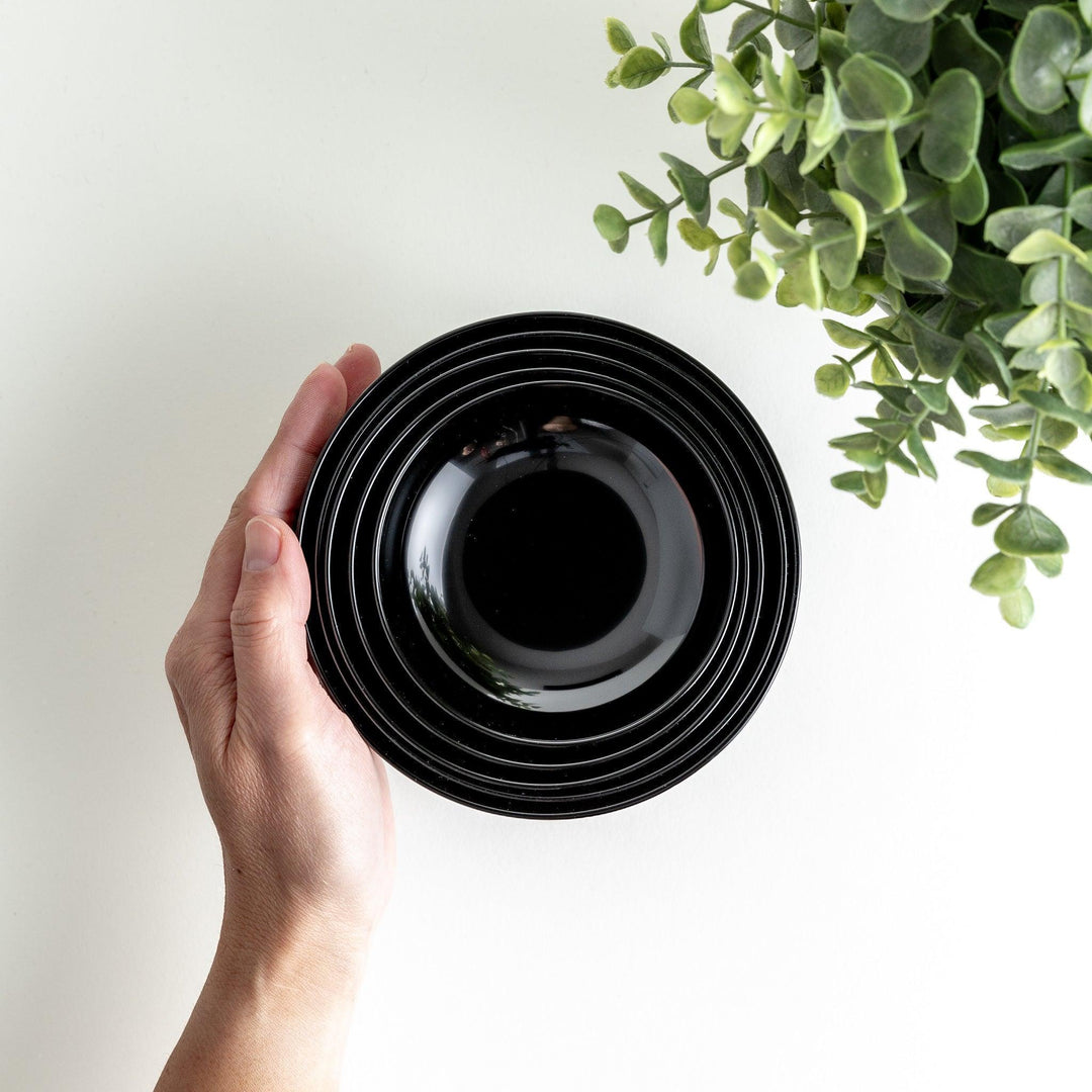 Set of five nested lacquer bowls with footed bases used in Japanese oryoki meals for formal mindful dining.