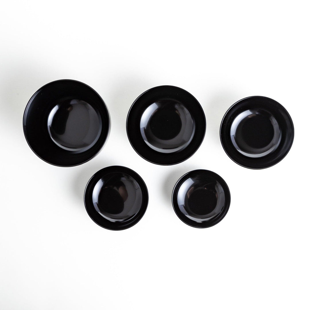 Set of five nested lacquer bowls with footed bases used in Japanese oryoki meals for formal mindful dining.