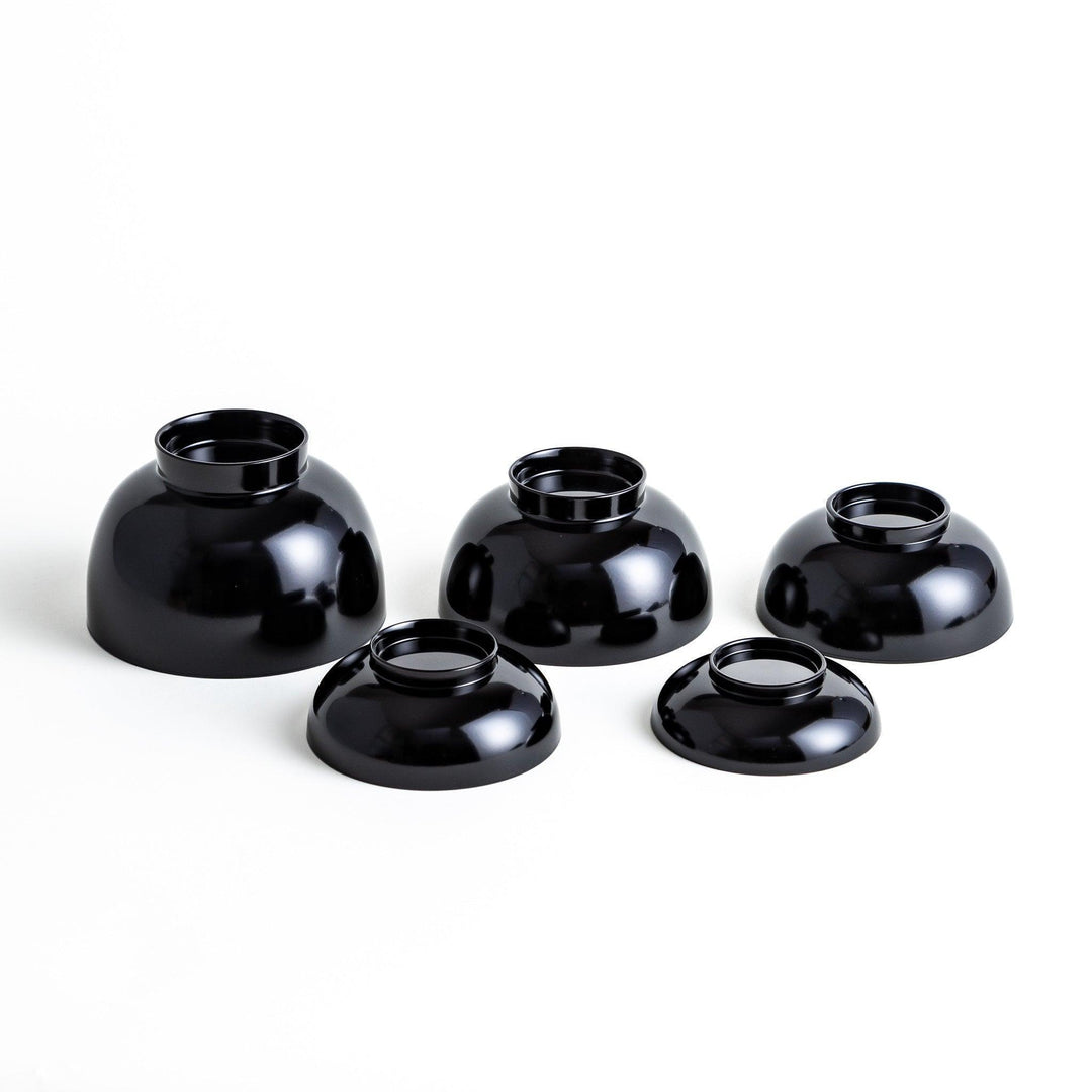 Set of five nested lacquer bowls with footed bases used in Japanese oryoki meals for formal mindful dining.