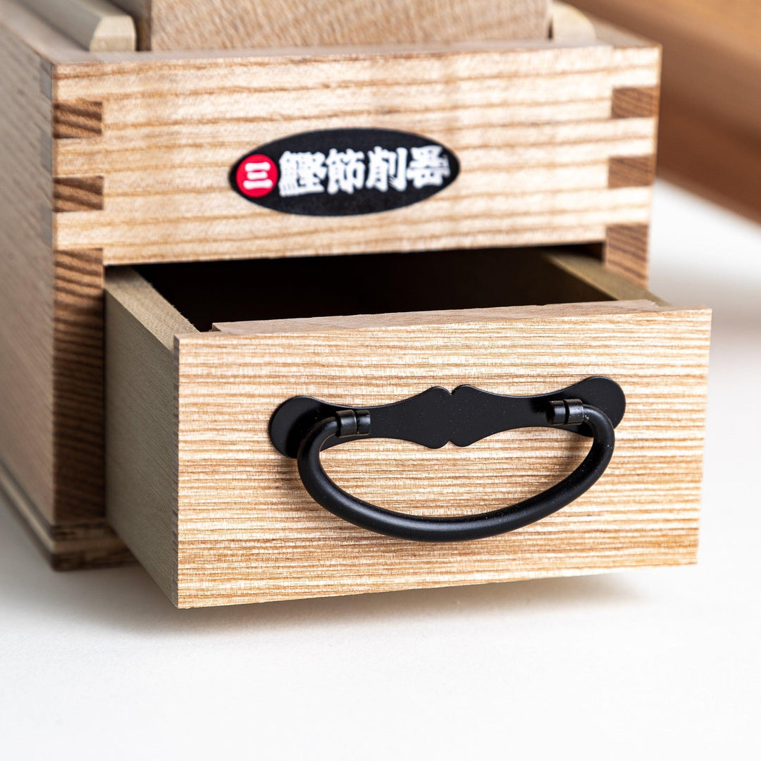 Large wooden katsuobushi shaver box with sliding drawer and lid and colorful Japanese artwork packaging.