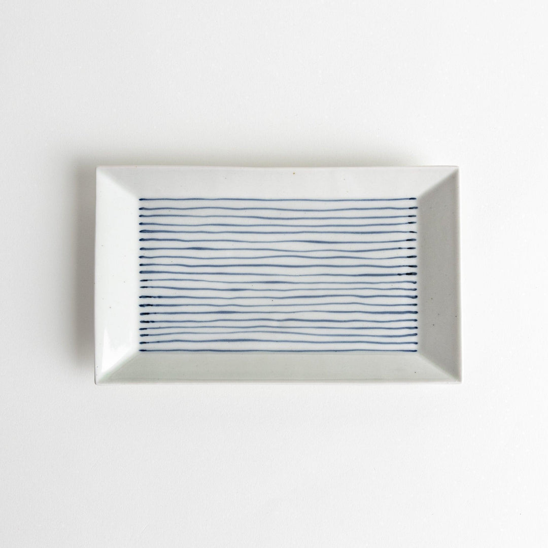 A rectangular ceramic plate with blue horizontal stripes, simple and elegant design.