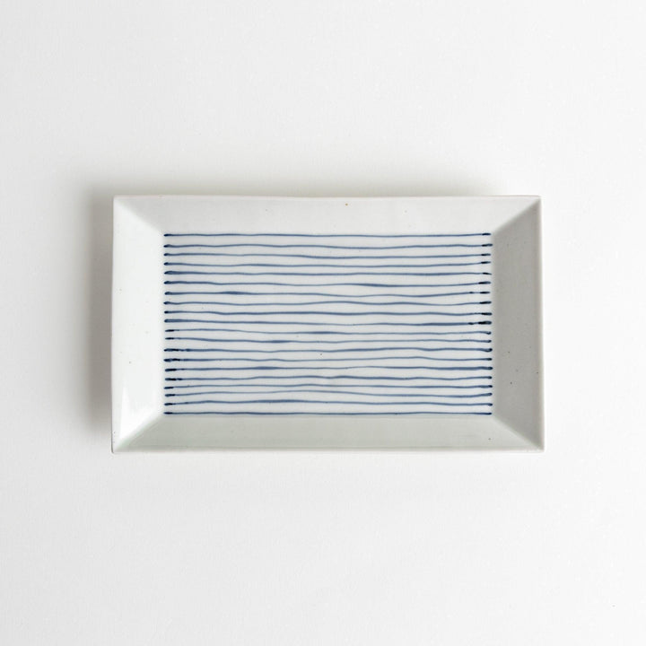 A rectangular ceramic plate with blue horizontal stripes, simple and elegant design.