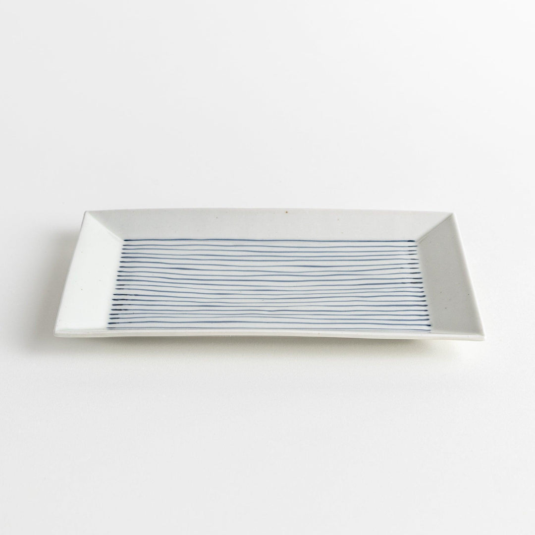 A rectangular ceramic plate with blue horizontal stripes, simple and elegant design.
