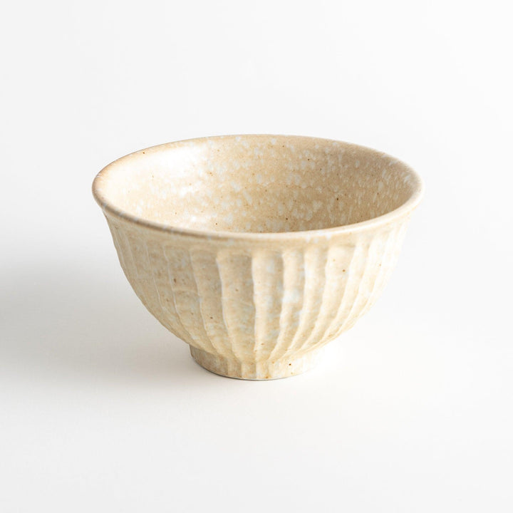 A beige ceramic rice bowl with a natural, rustic texture and a ribbed design.