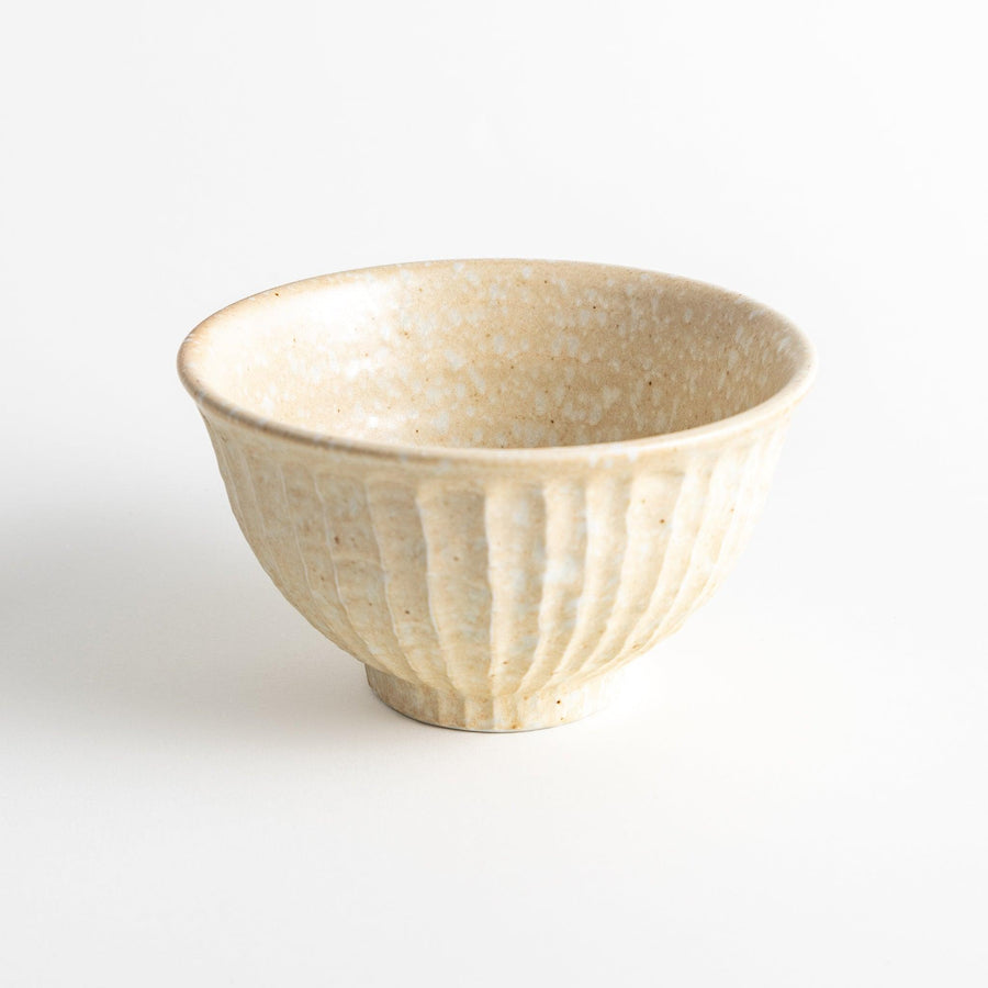 A beige ceramic rice bowl with a natural, rustic texture and a ribbed design.