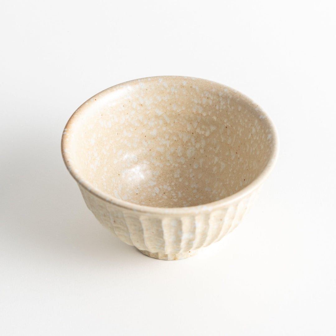 A beige ceramic rice bowl with a natural, rustic texture and a ribbed design.
