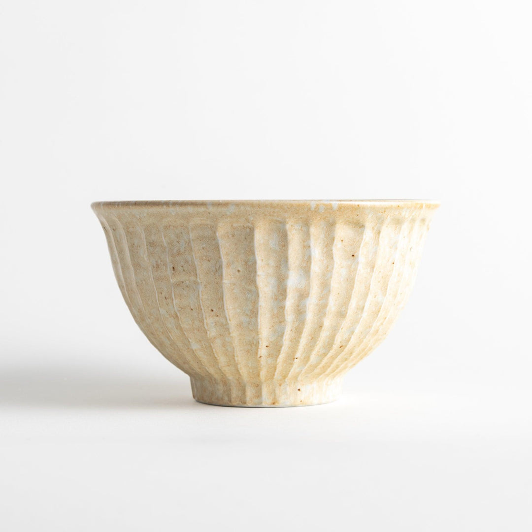 A beige ceramic rice bowl with a natural, rustic texture and a ribbed design.