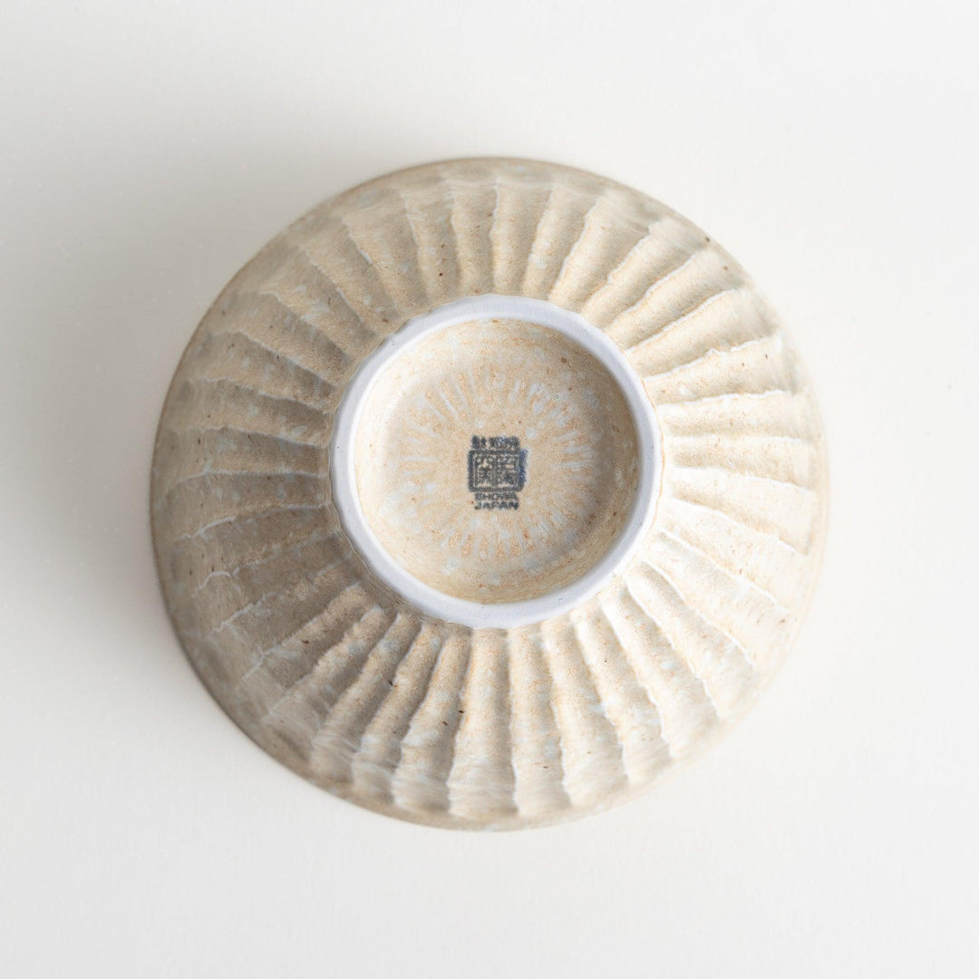 A beige ceramic rice bowl with a natural, rustic texture and a ribbed design.