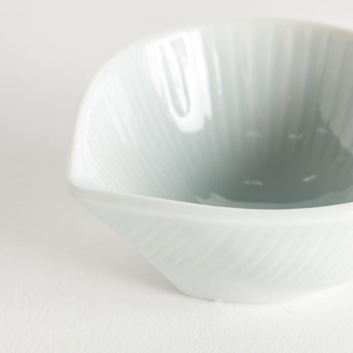 A small white condiment dish with a subtle ribbed pattern.