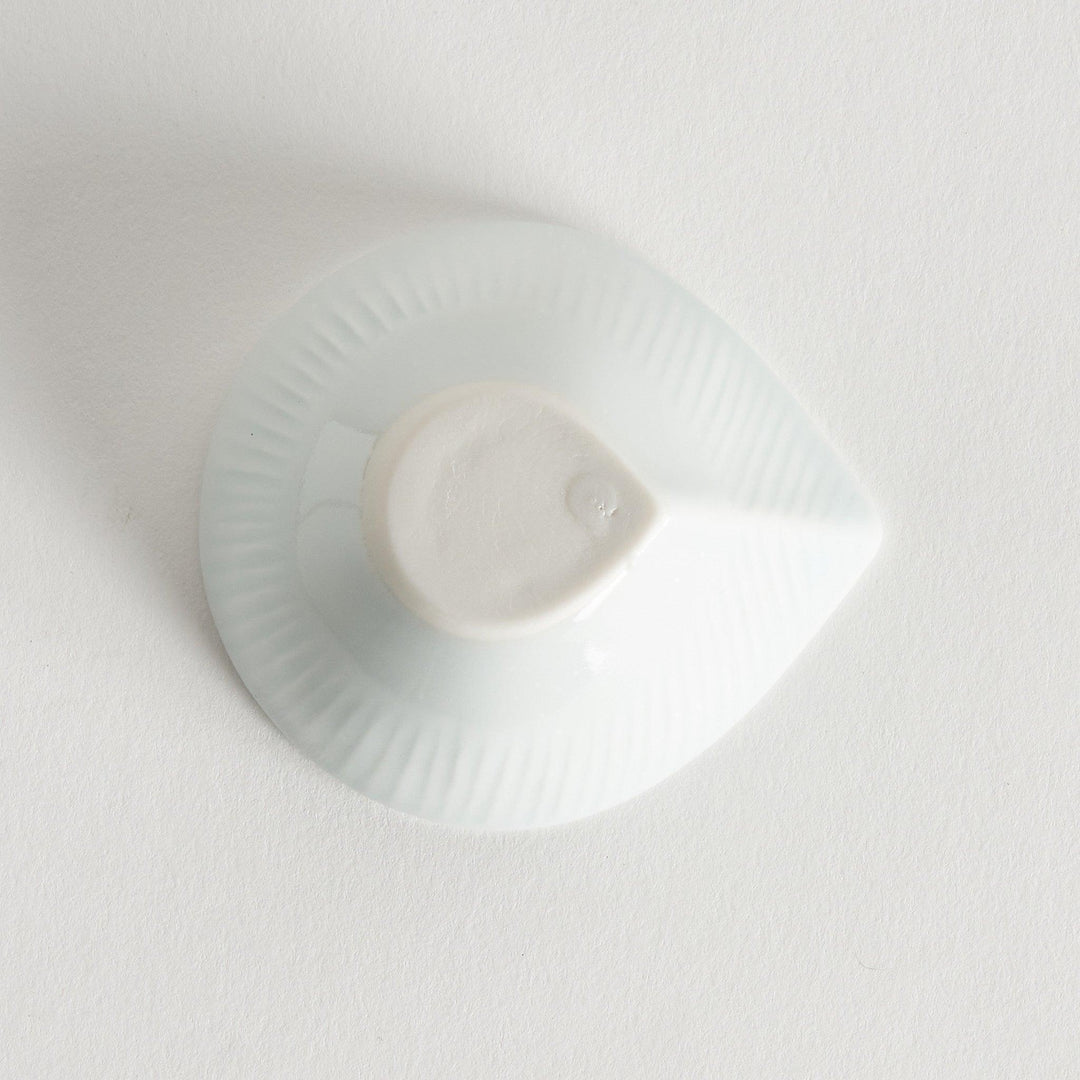 A small white condiment dish with a subtle ribbed pattern.